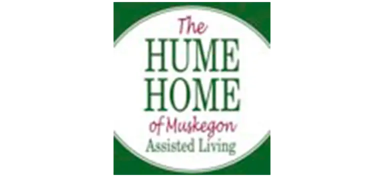 Logo for The Hume Home of Muskegon Assisted Living, featuring red and green text on a white oval background with a green border. Perfect for representing the warmth and care at Hume Home in Muskegon.