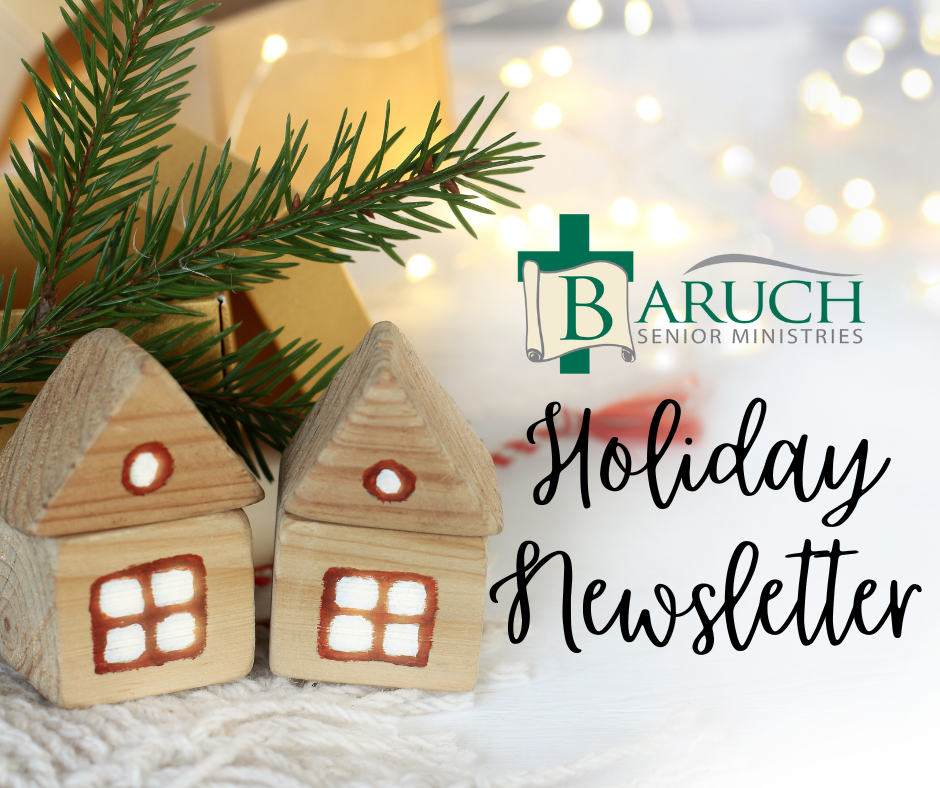 Two small wooden house ornaments and a pine sprig sit beside the "Baruch Senior Ministries Holiday Newsletter" text, with blurred holiday lights twinkling softly in the background.