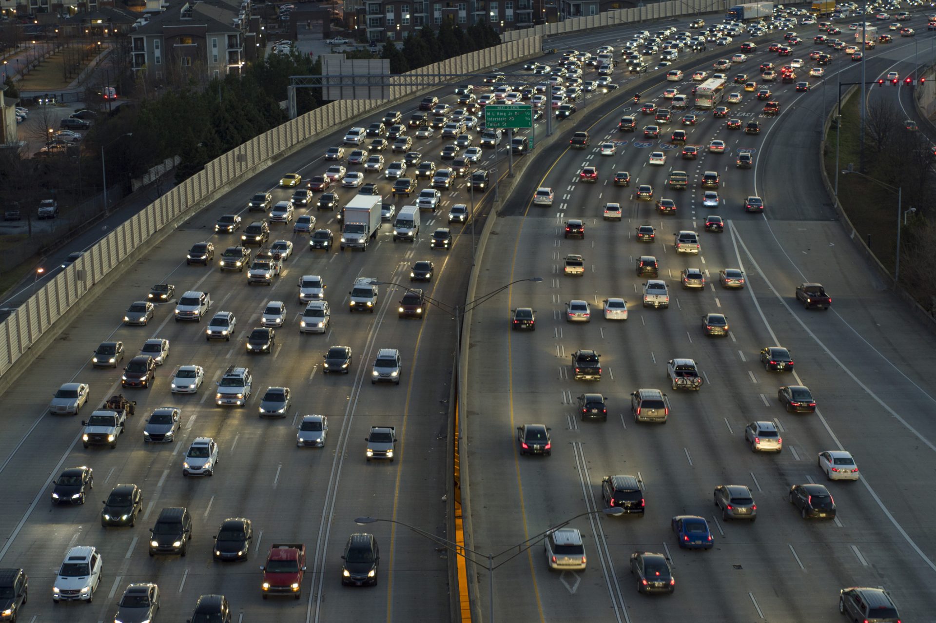 Aerial view of heavy traffic on a multi-lane highway during dusk, capturing cars moving in both directions—a scene reflecting life’s journey, where moments of spiritual care guide us through the rush.