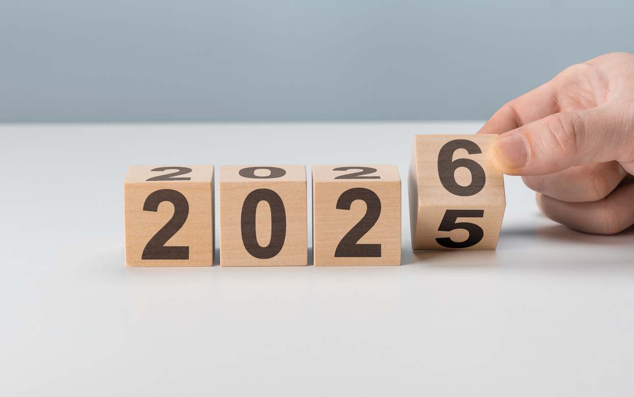 A hand rotates a wooden block from 2025 to 2026, with blocks displaying the years 2023, 2024, 2025, and 2026—perfect for a January Spiritual Care Blog reflecting on how God is Making All Things New.